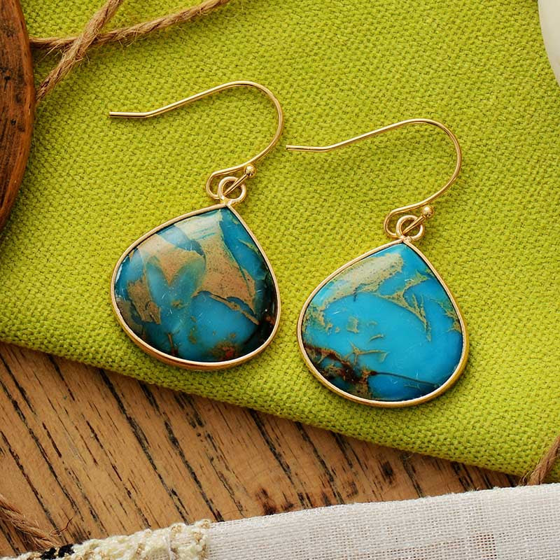 Pair of 18K gold-plated natural stone earrings featuring vibrant turquoise stones on a colorful background.
