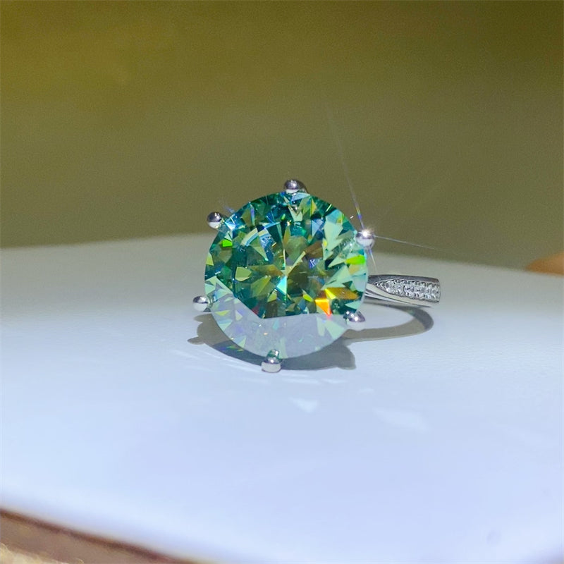 10 Carat Moissanite ring in 925 sterling silver with a vibrant green stone, displayed elegantly on a flat surface.