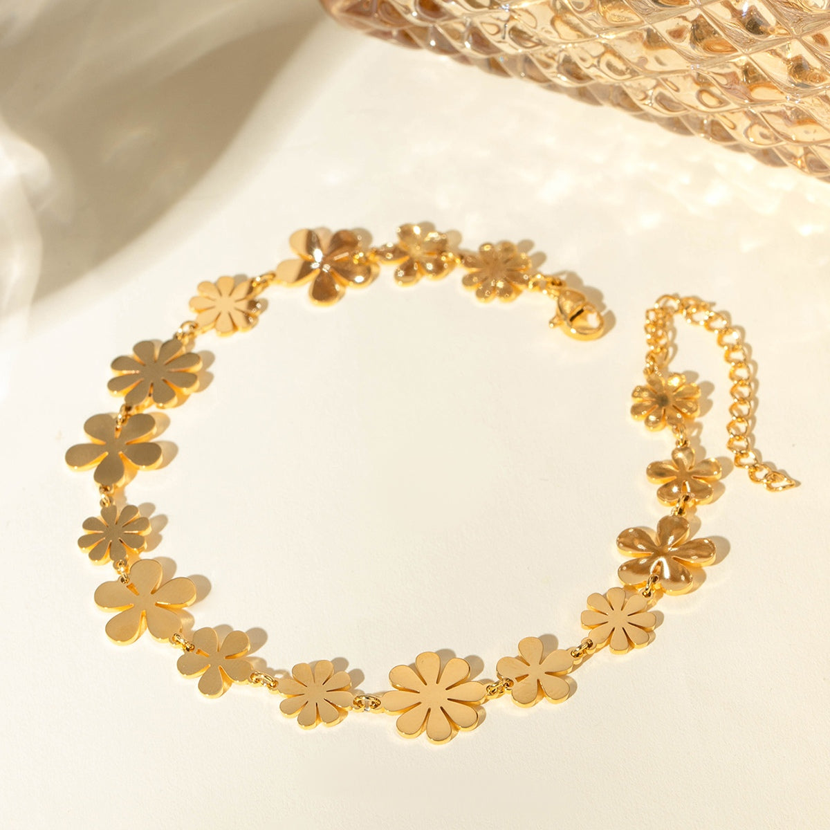 18K gold-plated flower bracelet with multiple floral designs and an extension chain, perfect for elegant accessories.